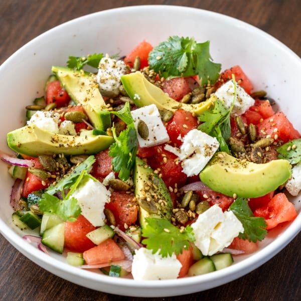 El Cedro's Lebanese watermelon salad with avocado, feta, pumpkin seeds, and cilantro in a white bowl.