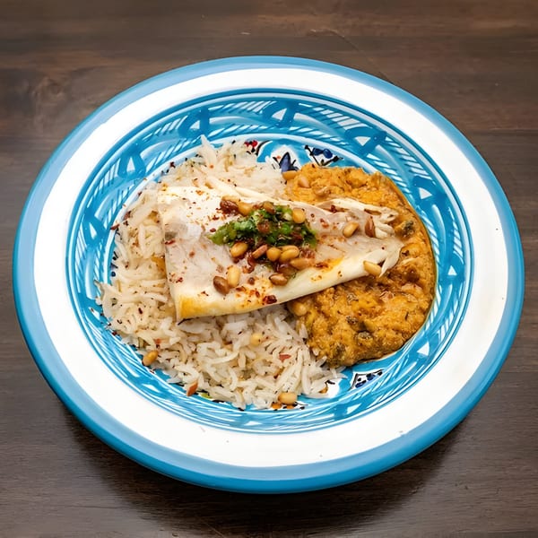 Lebanese dish with rice, flatbread topped with pine nuts and herbs, and a side of stew.